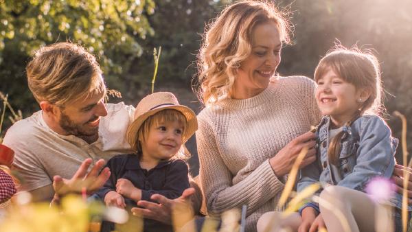 image of family sitting in the grass together