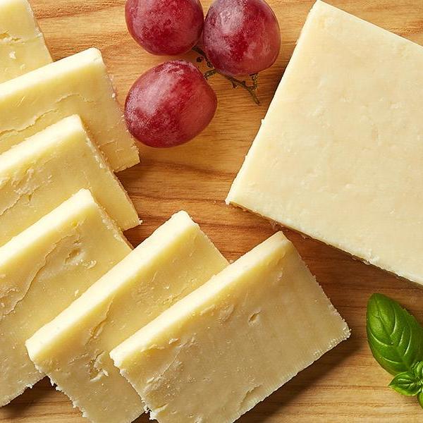 board with different types of cheese and grapes