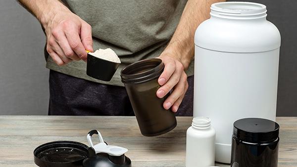 man with shaker and scoop of promiko powder
